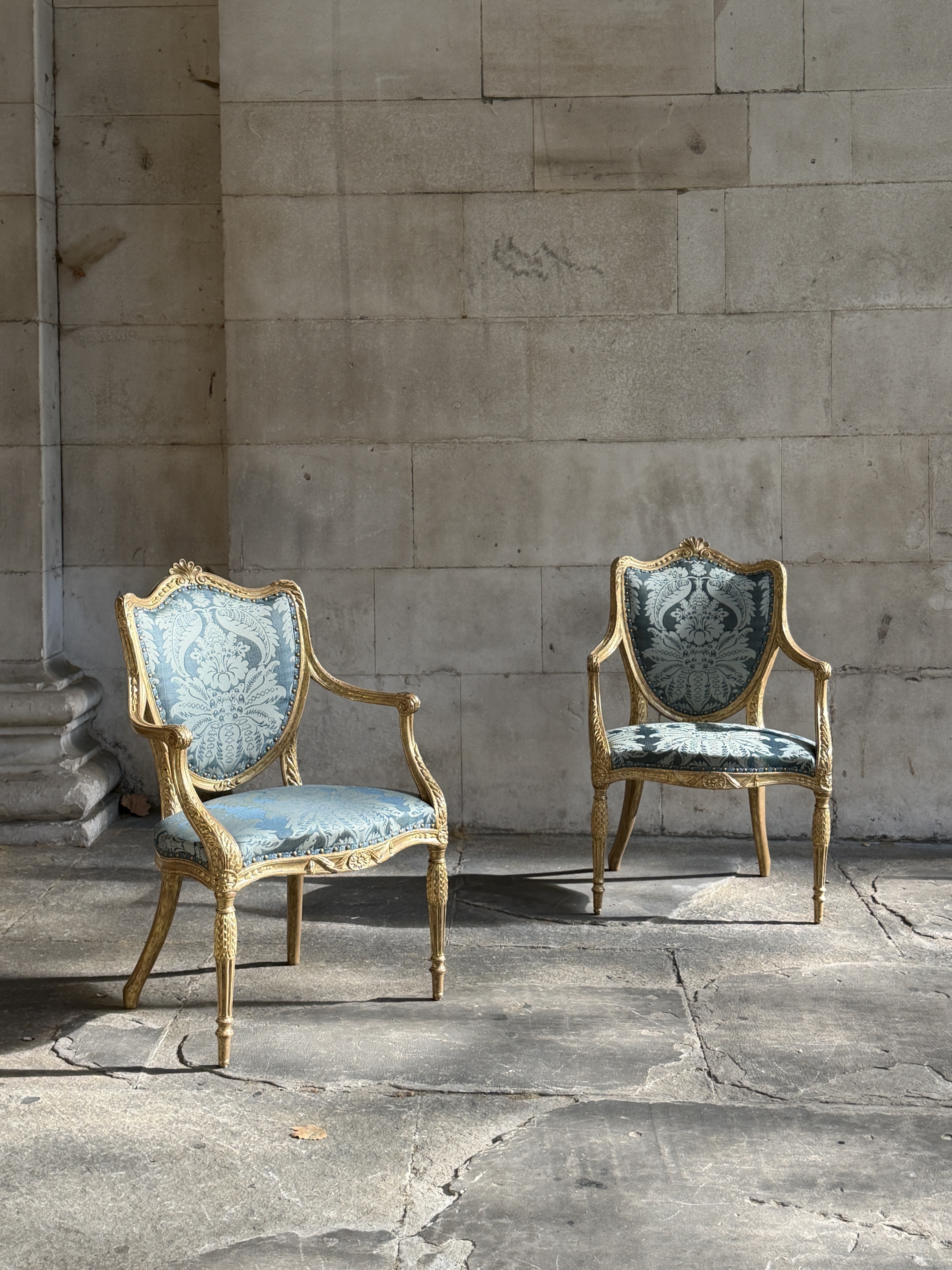 A PAIR OF GEORGE III PERIOD GILTWOOD ARMCHAIRS