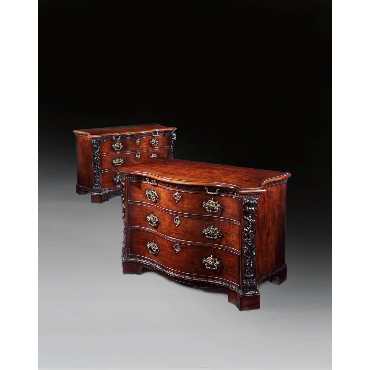 A PAIR OF GEORGE II PERIOD SERPENTINE FRONTED MAHOGANY COMMODES ATTRIBUTED TO THE WORKSHOP OF WILLIAM VILE OR WILLIAM HALLETT THE CARVING POSSIBLY BY JOHN BOSON