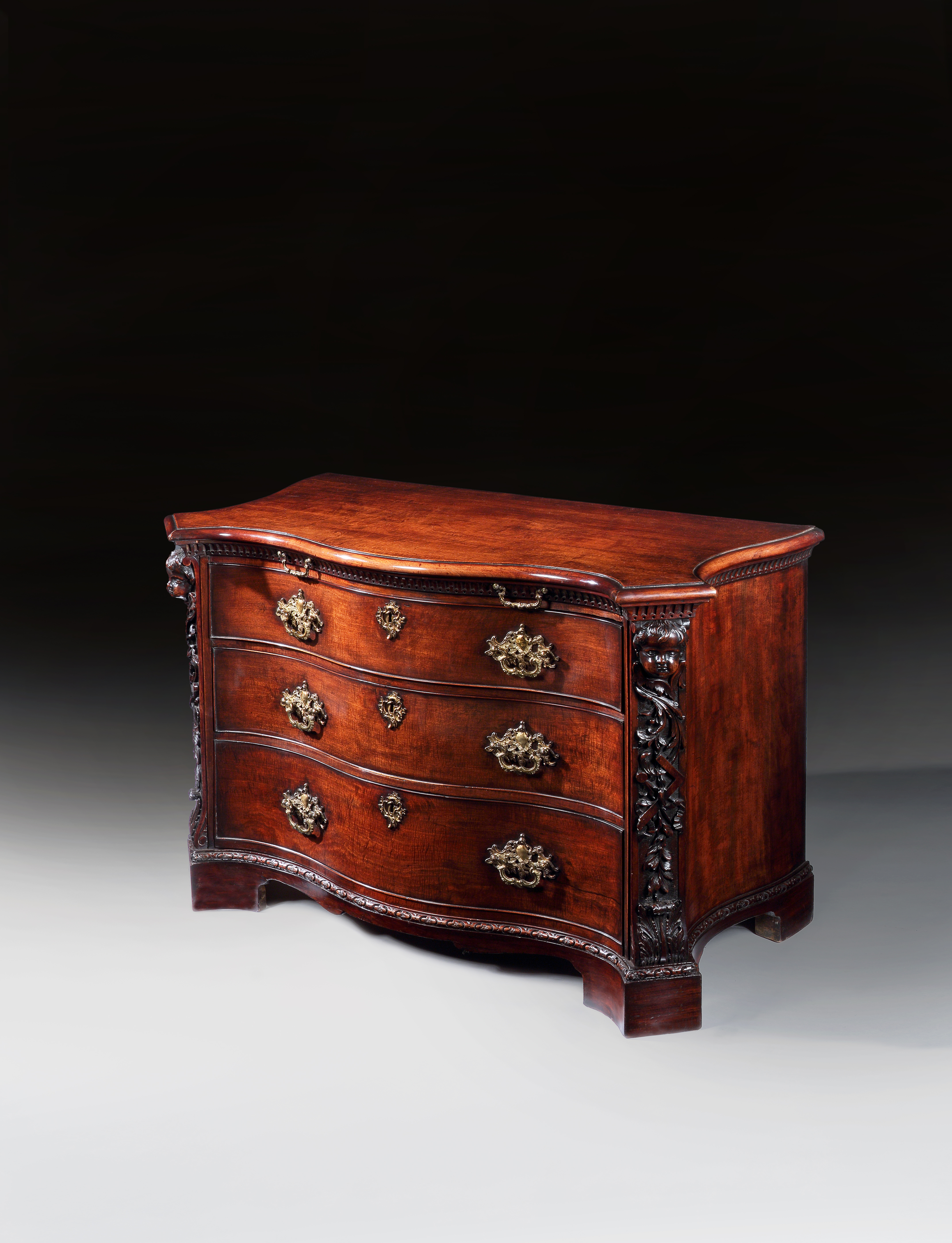 A PAIR OF GEORGE II PERIOD SERPENTINE FRONTED MAHOGANY COMMODES ATTRIBUTED TO THE WORKSHOP OF WILLIAM VILE OR WILLIAM HALLETT THE CARVING POSSIBLY BY JOHN BOSON